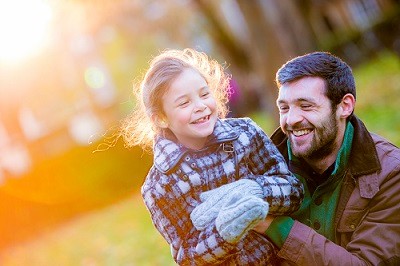 Man and young girl laughing outside